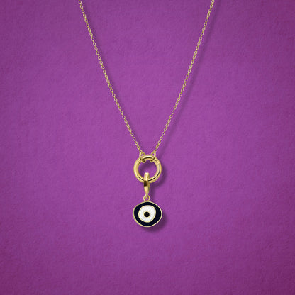Close-up of the Obsidian Organic Evil Eye Charm with hand-painted enamel on a 14K solid gold cable chain necklace, shown on a magenta background.