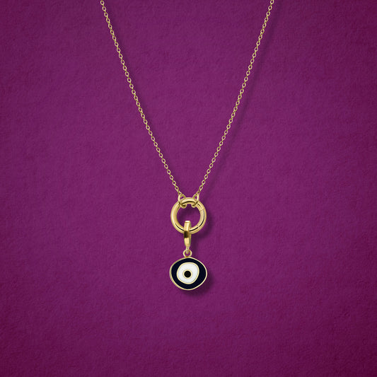 Close-up of the Obsidian Organic Evil Eye Charm with hand-painted enamel on a 14K solid gold cable chain necklace, shown on a magenta background.
