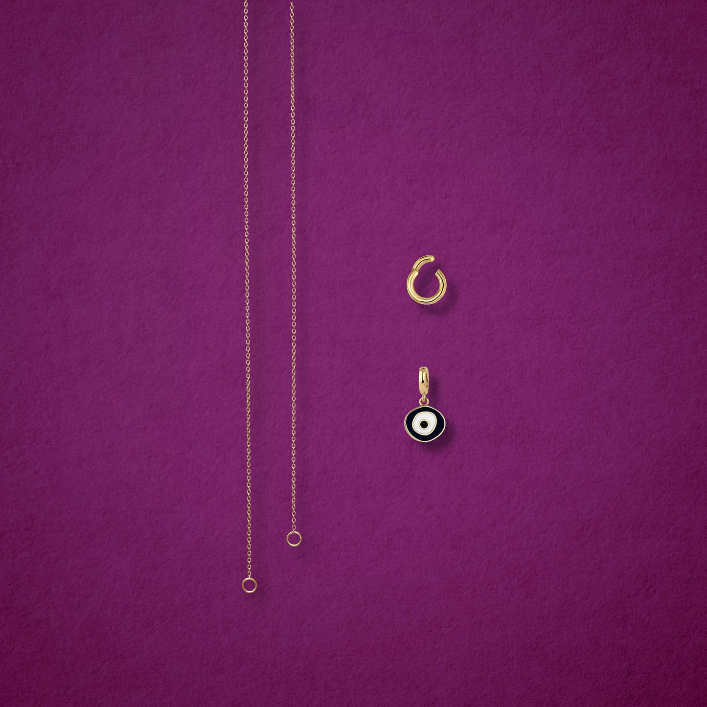 Obsidian Organic Evil Eye Charm, Golden Link Charm Holder, and the Golden Grace cable chain necklace displayed separately on a magenta background to show styling options.