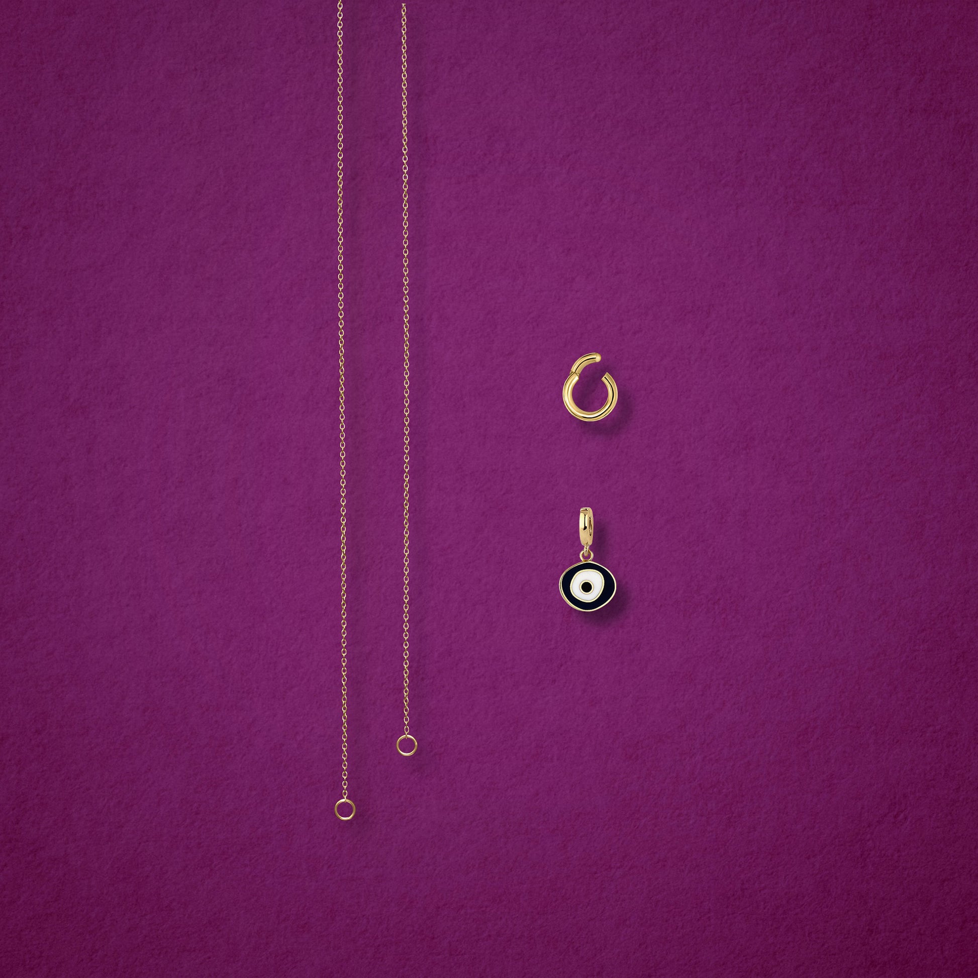Obsidian Organic Evil Eye Charm, Golden Link Charm Holder, and the Golden Grace cable chain necklace displayed separately on a magenta background to show styling options.