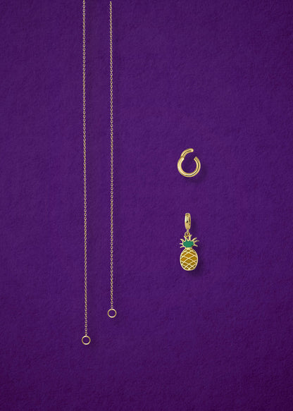 Separated components of the Golden Grace Pineapple Paradise Charm Necklace, including 14K solid gold cable chain, golden link charm holder, and pineapple paradise charm with green enamel by whywhy NYC.