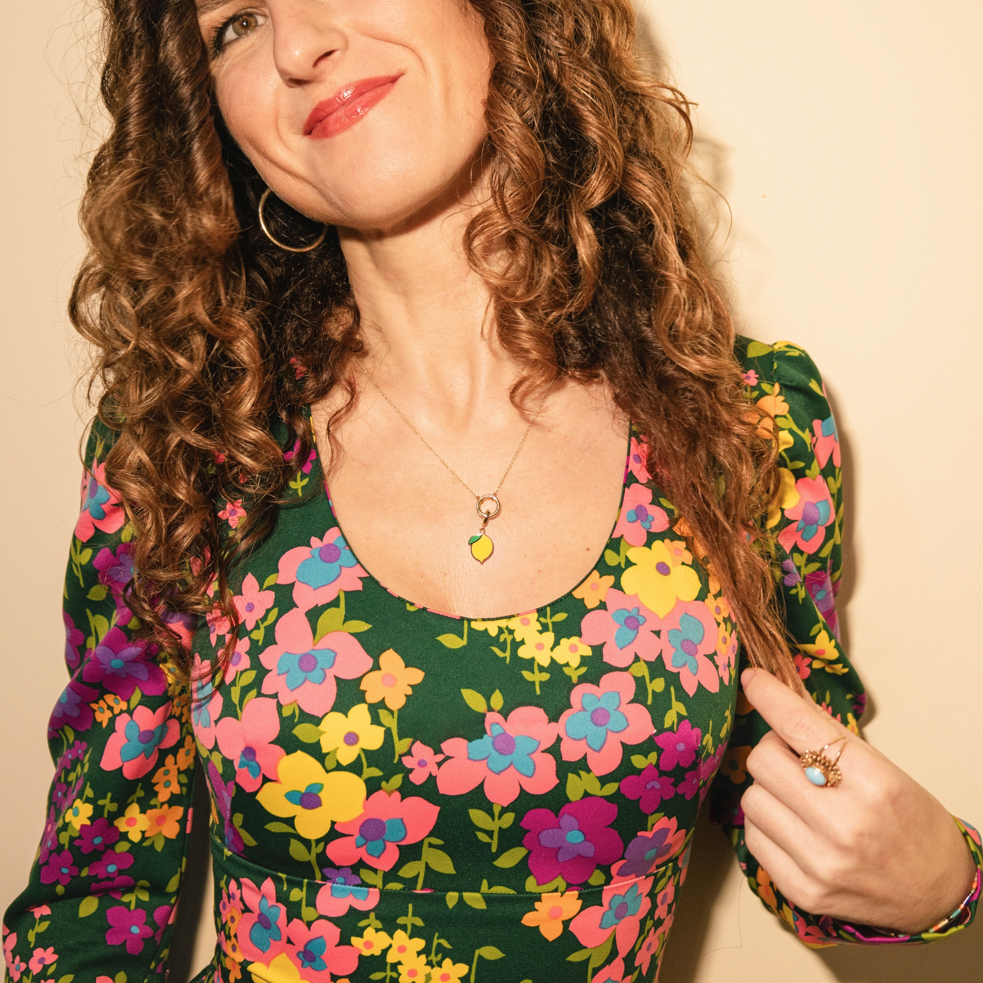 Lifestyle photo of a model wearing the Golden Grace Zesty Lemon Charm Necklace in 14K solid gold, paired with a vibrant floral dress, blending playful luxury with everyday elegance.
