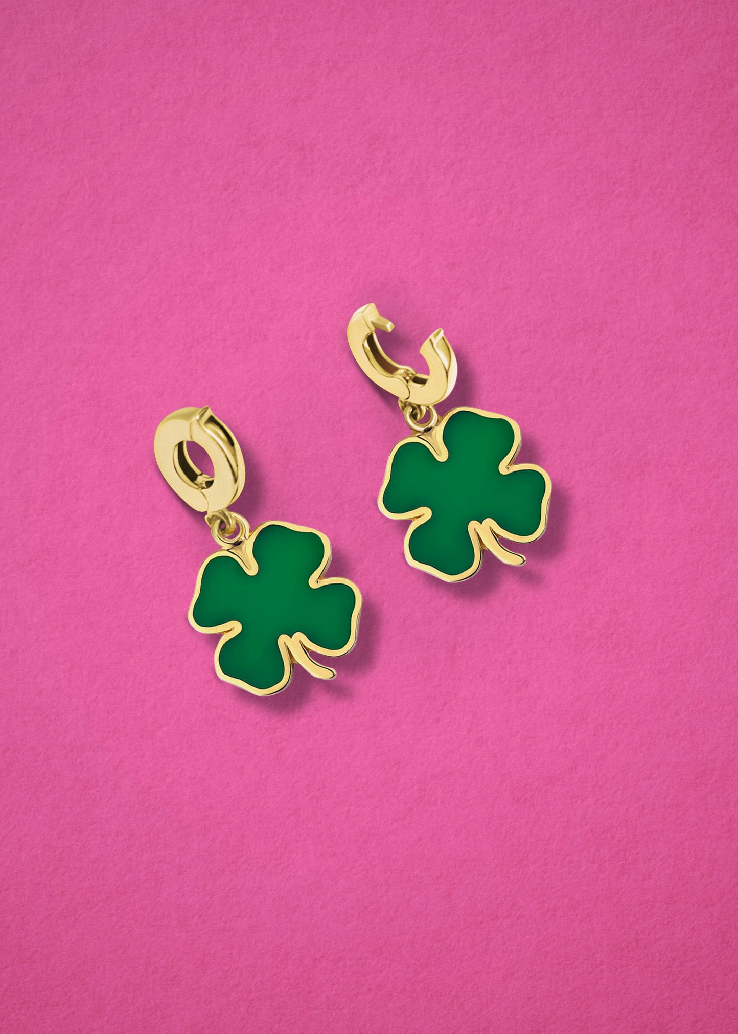 Lucky Clover Charm showing both open and closed views of the 14K solid gold clip, with bright green enamel, displayed on a pink background.