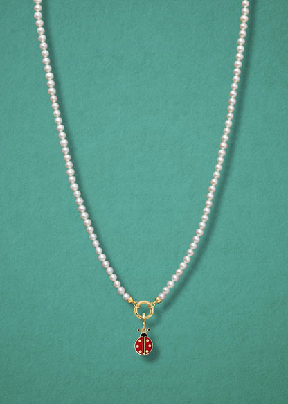 Lucky Ladybird Charm paired with the Lustrous Pearl Charm Necklace by whywhy NYC, featuring 14K solid gold and hand-painted enamel for a playful, elegant look.