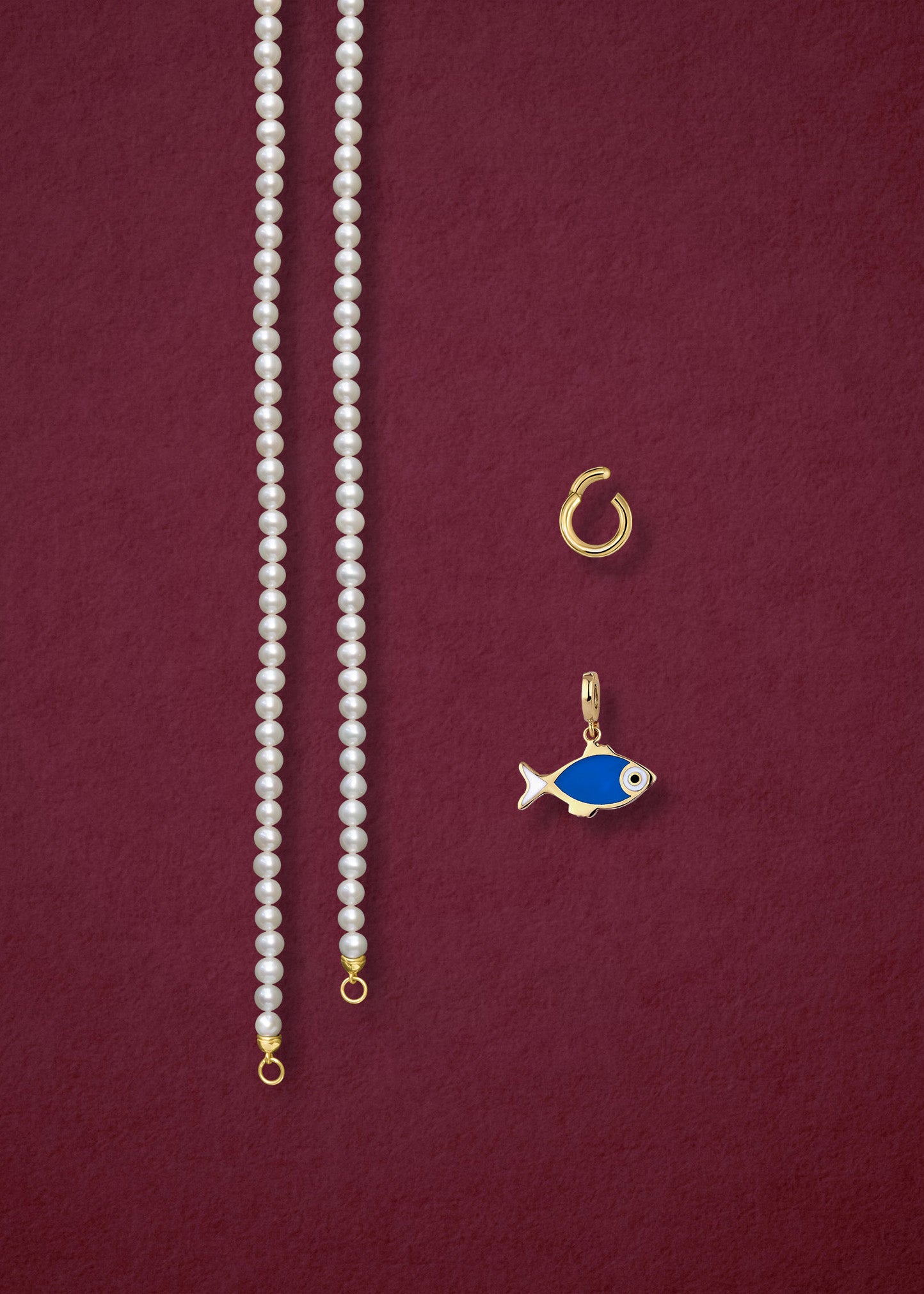 Separated components of the Lustrous Pearl Fishy Wishes Charm Necklace, including pearl necklace, charm holder, and fishy wishes charm in 14K solid gold by whywhy NYC.