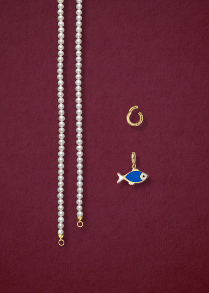 Separated components of the Lustrous Pearl Fishy Wishes Charm Necklace, including pearl necklace, charm holder, and fishy wishes charm in 14K solid gold by whywhy NYC.