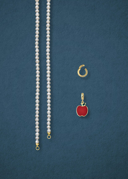 Separated components of the Lustrous Pearl Golden Apple of NYC Charm Necklace, including pearl necklace, charm holder, and golden apple charm in 14K solid gold by whywhy NYC.