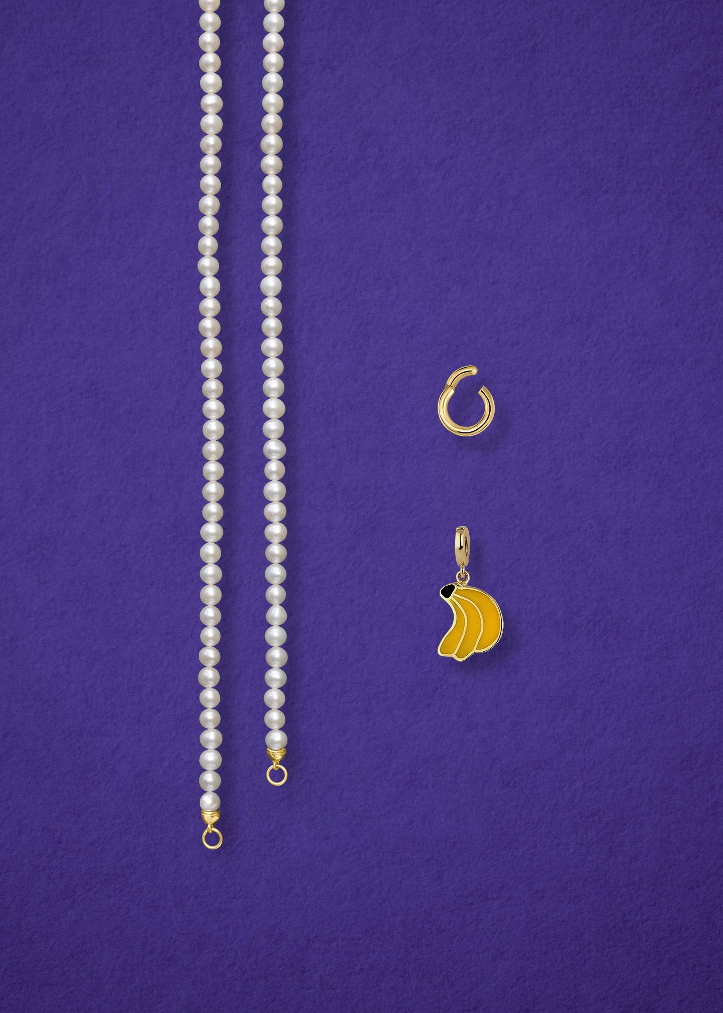 Separated components of the Lustrous Pearl Banana Bliss Charm Necklace, including pearl necklace, charm holder, and banana bliss charm in 14K solid gold by whywhy NYC.