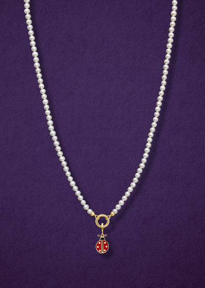 Lustrous Pearl Charm Necklace paired with the Lucky Ladybird Charm by whywhy NYC, featuring 14K solid gold and hand-painted enamel for a playful, elegant look.