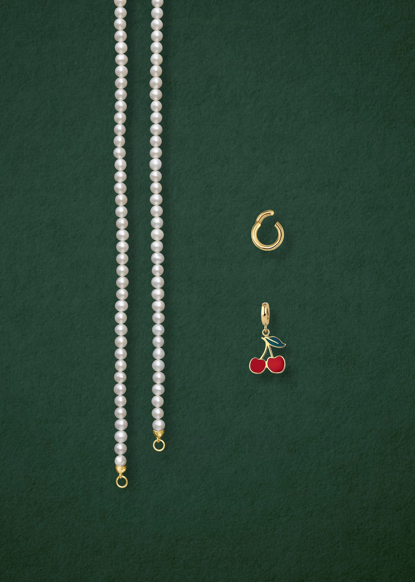 Separated components of the Lustrous Pearl Cherry on Top Charm Necklace, including pearl necklace, charm holder, and cherry on top charm in 14K solid gold by whywhy NYC.
