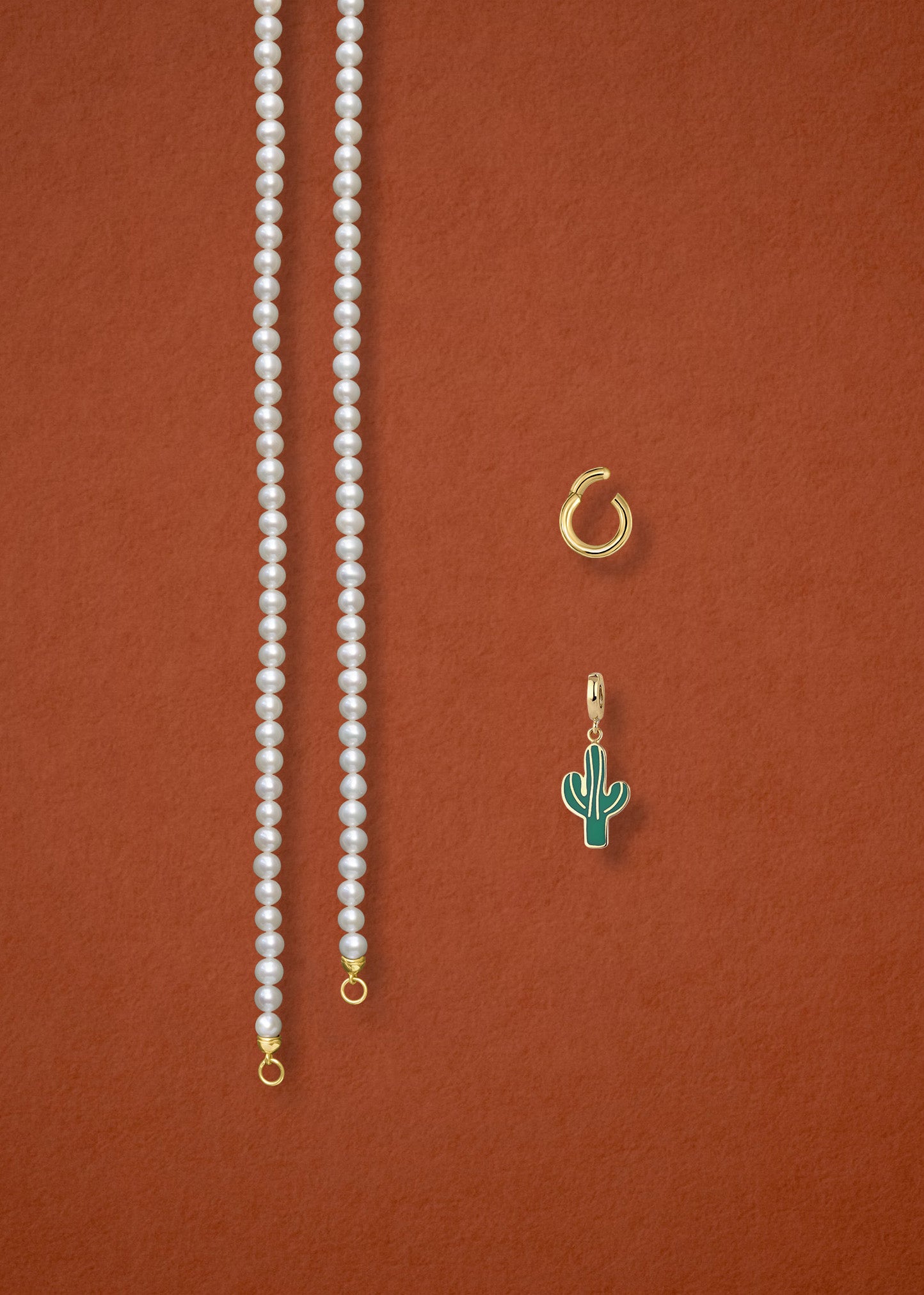 Separated components of the Lustrous Pearl Desert Bloom Charm Necklace, including pearl necklace, charm holder, and desert bloom charm in 14K solid gold by whywhy NYC.