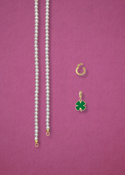 Separated components of the Lustrous Pearl Lucky Clover Charm Necklace, including pearl necklace, charm holder, and lucky clover charm in 14K solid gold by whywhy NYC.