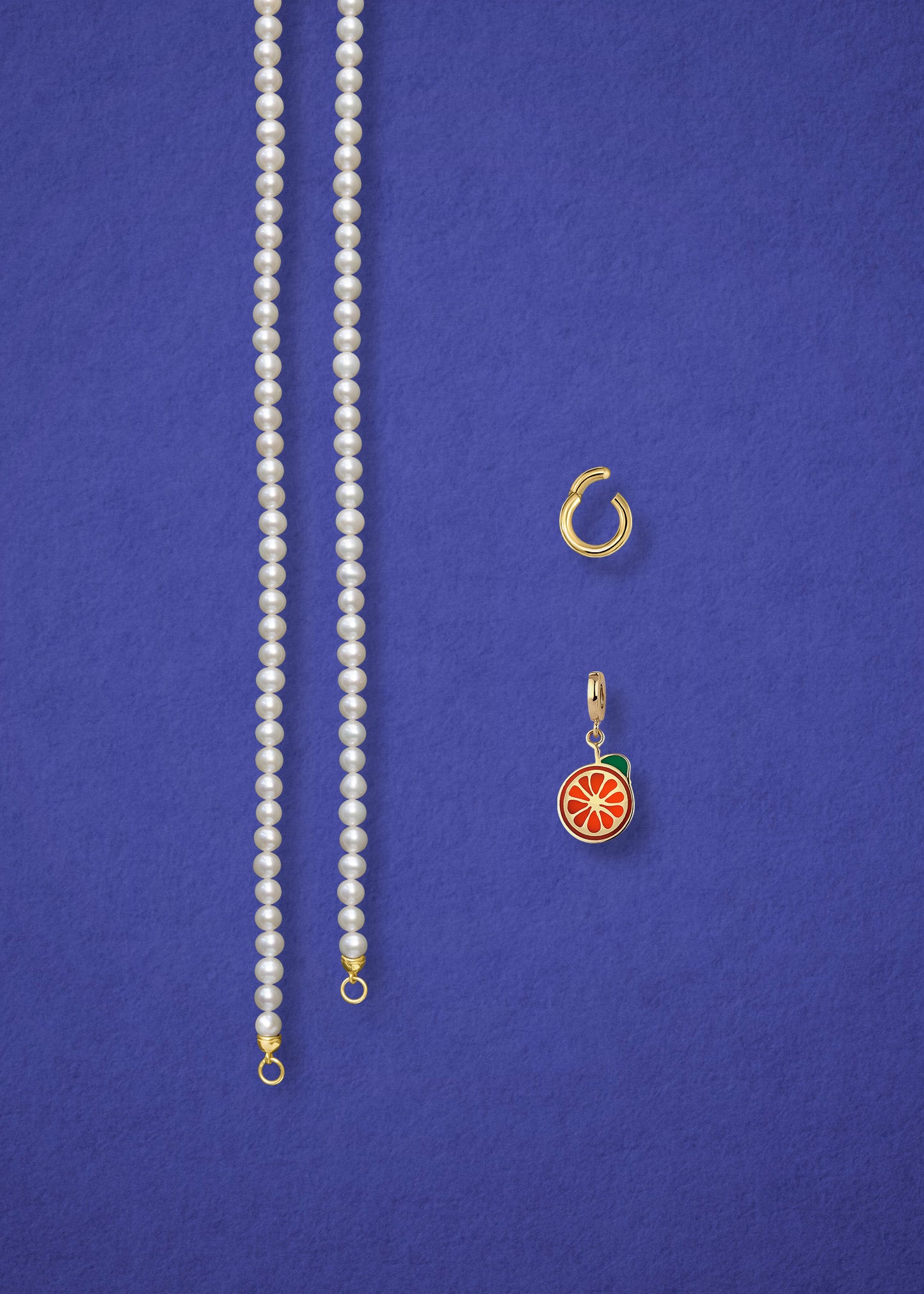 Separated components of the Lustrous Pearl Orange Crush Charm Necklace, including pearl necklace, charm holder, and orange crush charm in 14K solid gold by whywhy NYC.