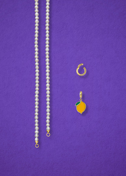 Separated components of the Lustrous Pearl Zesty Lemon Charm Necklace, including pearl necklace, charm holder, and zesty lemon charm in 14K solid gold by whywhy NYC.