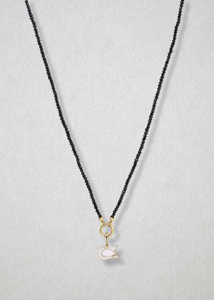 Noir Elegance Dove of Hope Charm Necklace in full view, showcasing faceted black spinel beads, a golden link charm holder, and dove of hope charm with white enamel by whywhy NYC.