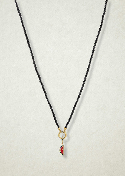Noir Elegance Watermelon Wonder Charm Necklace in full view, showcasing faceted black spinel beads, a golden link charm holder, and watermelon wonder charm with pink and green enamel by whywhy NYC.