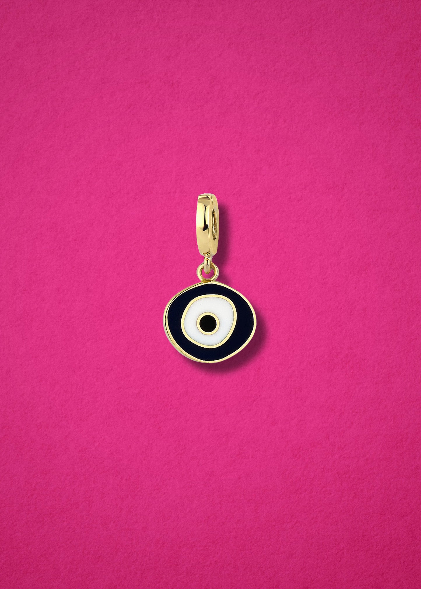 Obsidian Organic Evil Eye clip-on charm crafted in 14K solid gold with hand-painted white, and black enamel detailing, shown on a magenta.