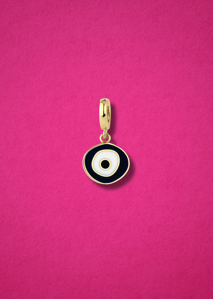 Obsidian Organic Evil Eye clip-on charm crafted in 14K solid gold with hand-painted white, and black enamel detailing, shown on a magenta.