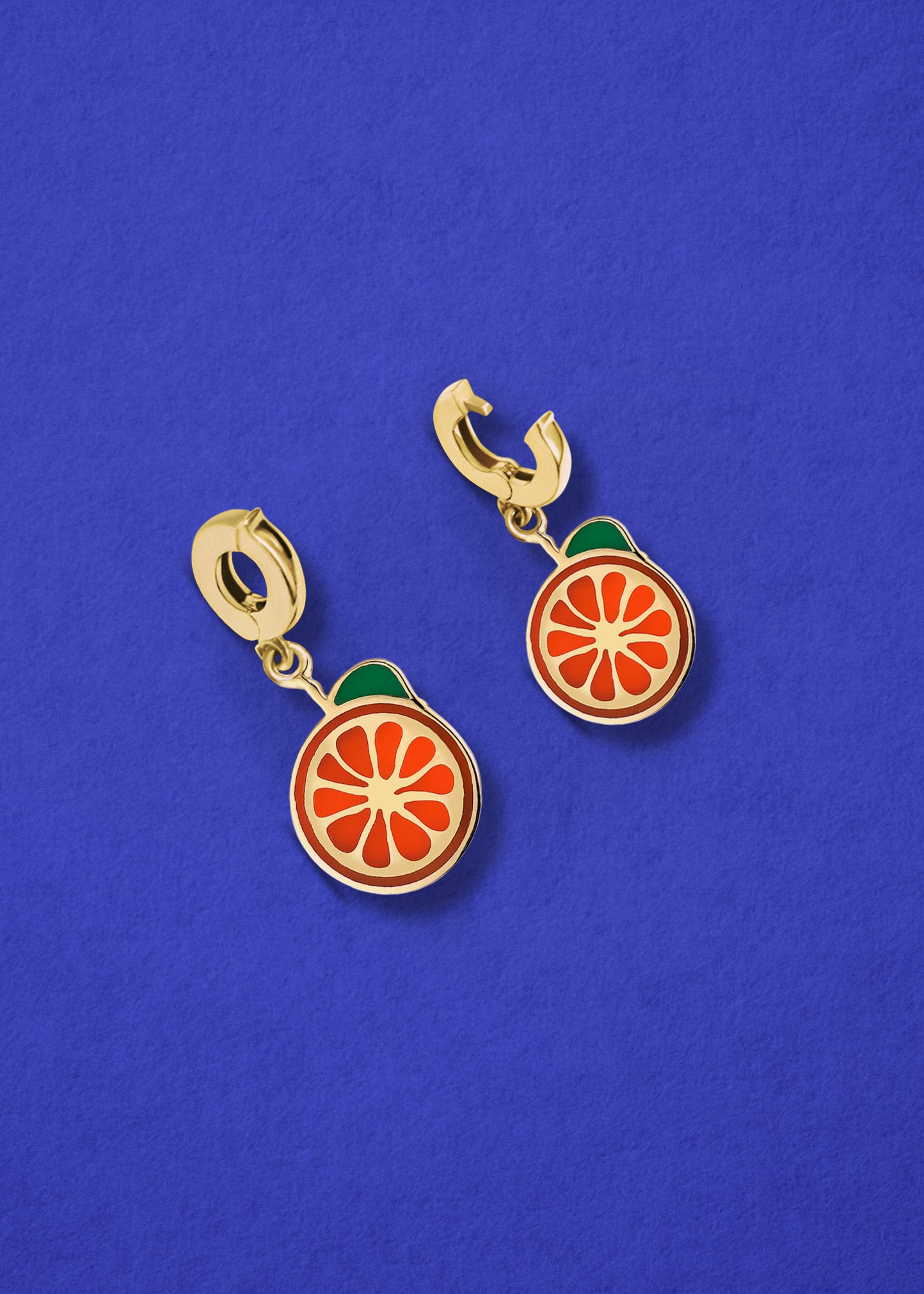 Orange Crush Charm showing both open and closed views of the 14K solid gold clip, with bright orange enamel, displayed on a blue background.