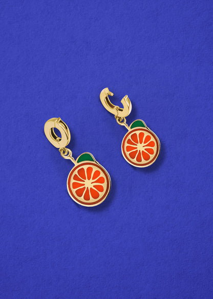 Orange Crush Charm showing both open and closed views of the 14K solid gold clip, with bright orange enamel, displayed on a blue background.