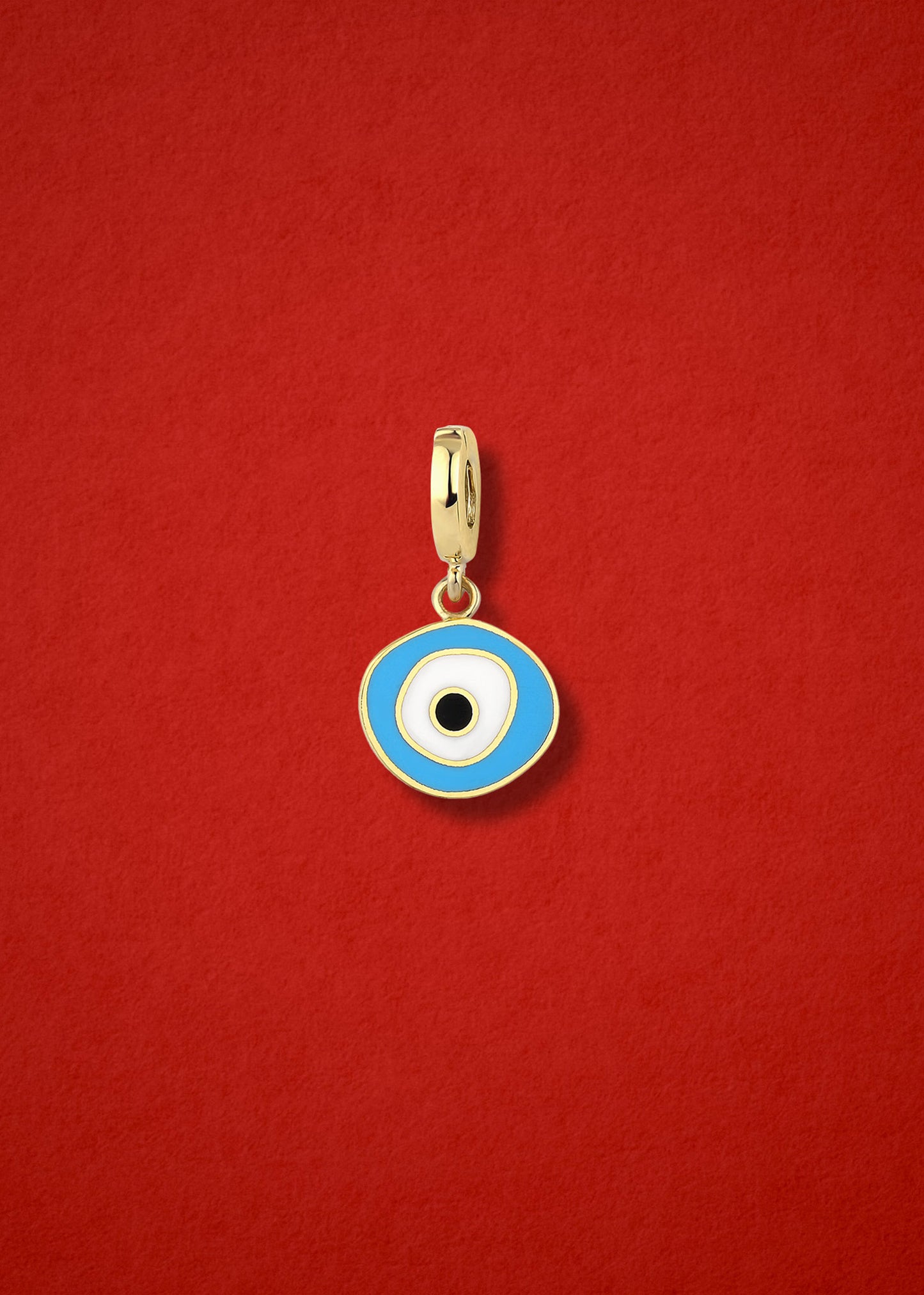 Sky Organic Evil Eye clip-on charm crafted in 14K solid gold with hand-painted sky blue, white, and black enamel detailing, shown on a red background.