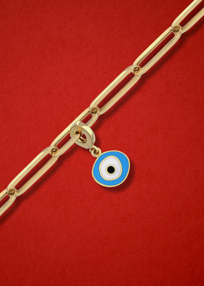 Sky Organic Evil Eye clip-on charm crafted in 14K solid gold with sky blue, white, and black enamel, shown hanging on a gold chain on a red background.