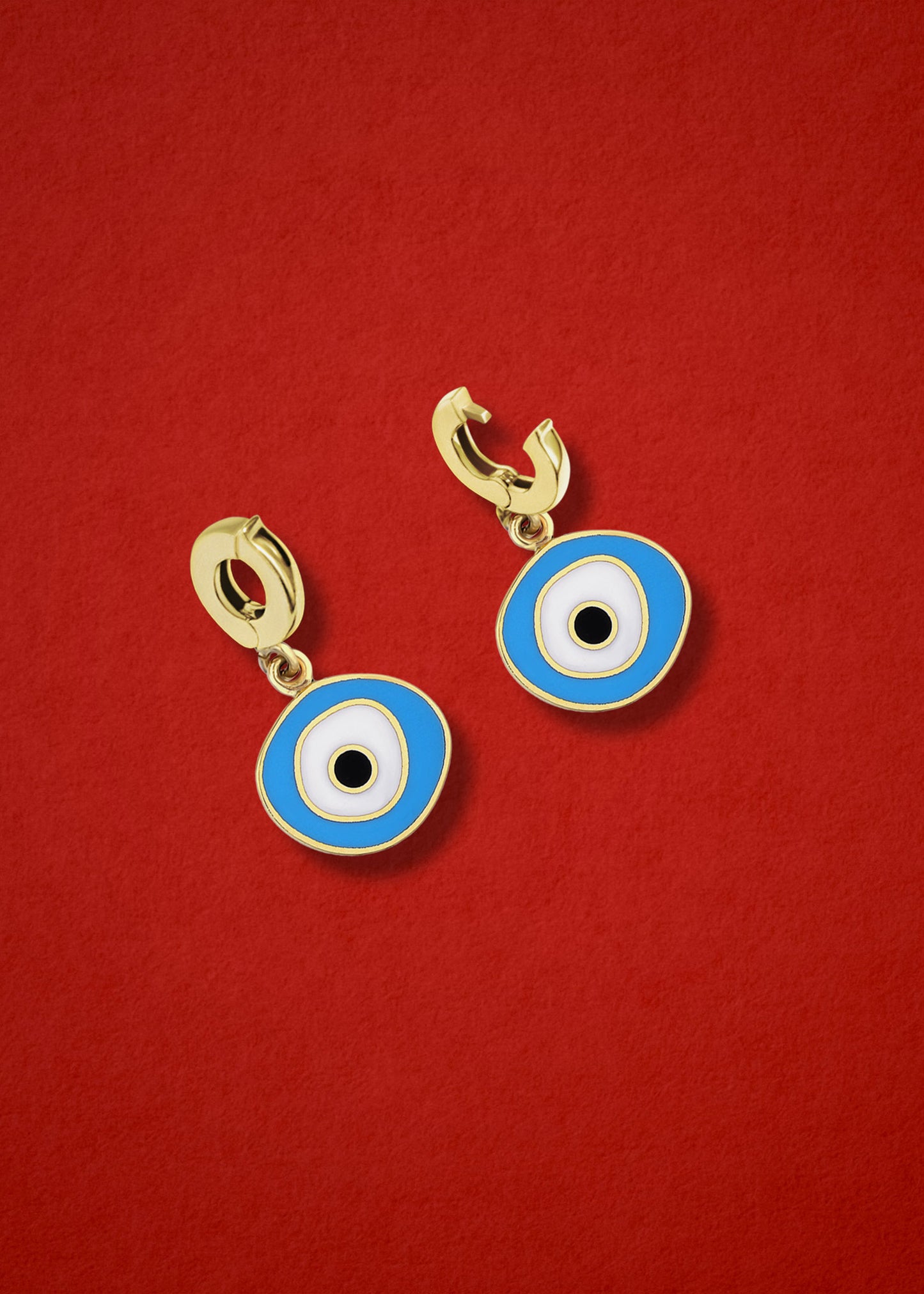 Clip-on bail of the 14K solid gold Sky Organic Evil Eye Charm shown in open and closed view on a red background.