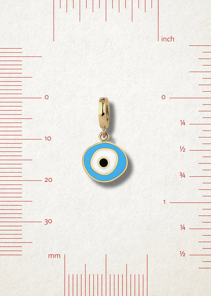 Sky Organic Evil Eye Charm with sky blue, white, and black enamel displayed beside measurement markers on a soft light background to show its size.
