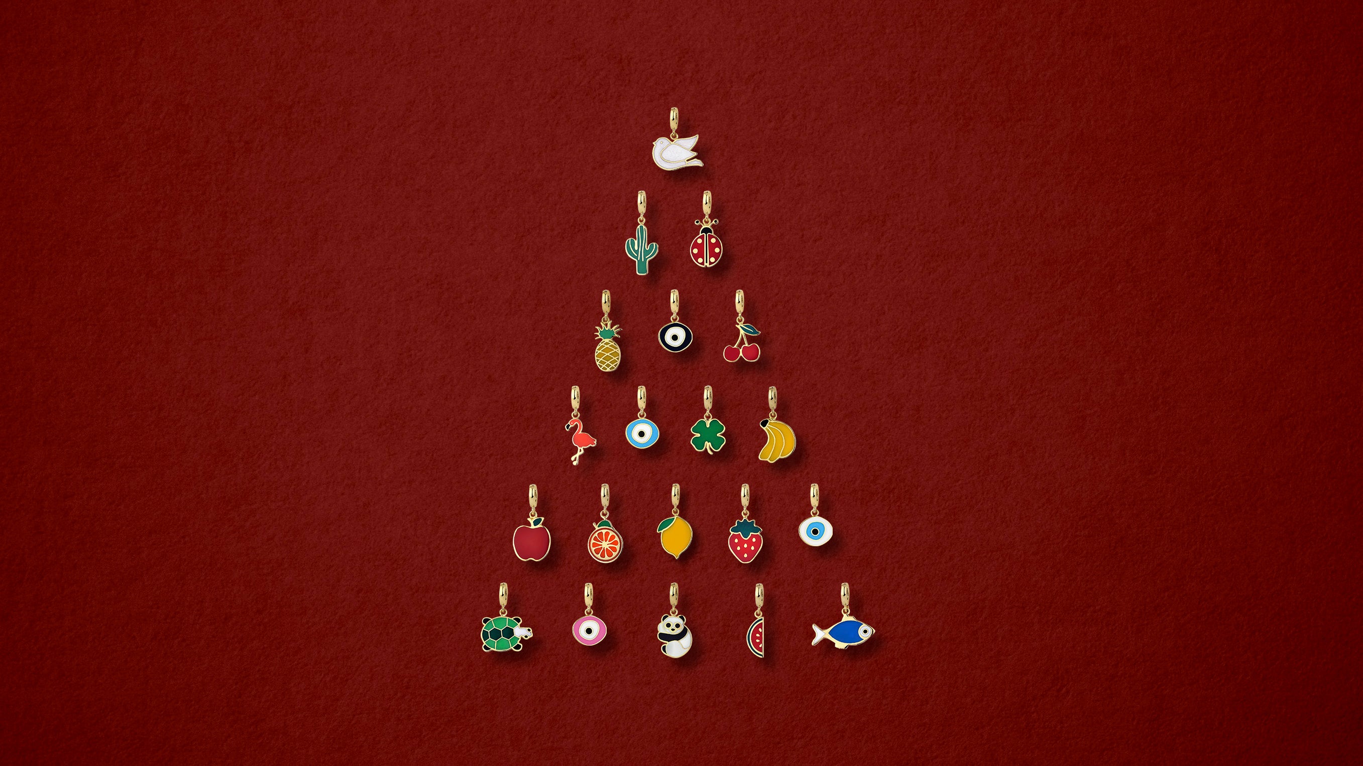 14K solid gold enamel charms arranged in a Christmas tree shape on a red background.